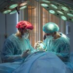 two men wearing blue lab coats